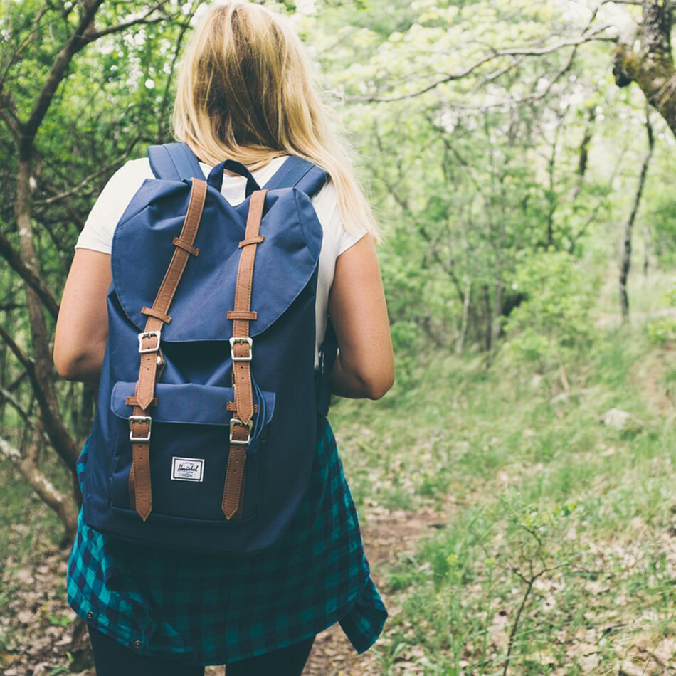 Woman hiking wearing a blue backpack